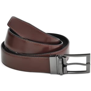 A brown leather reversible belt with a black underside and a silver buckle, featuring a logo.