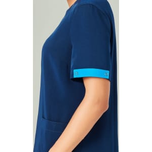 A navy blue unisex scrub with short sleeves featuring blue accents on the cuffs. It has a pocket on the side.