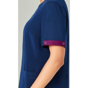 A navy blue scrub top with short sleeves featuring a maroon cuff detail and an attached logo.