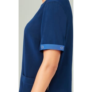 A navy blue unisex scrub top featuring short sleeves and a pocket, with a small metallic detail on the sleeve.