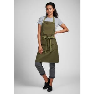 An olive green apron worn over a grey t-shirt, tied at the waist, paired with black pants and shoes.