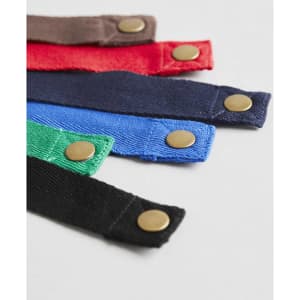 Various fabric bib straps in brown, red, green, blue, and black, featuring brass buttons, displayed together on a light background.