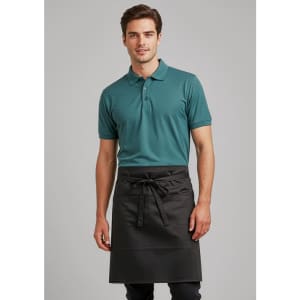 A man wearing a teal polo shirt and a black short-waisted apron. The apron has a tie closure and features a logo.