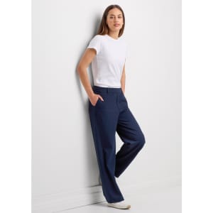 A pair of women's soft stretch pants in navy, worn by a model with a white t-shirt against a plain wall.