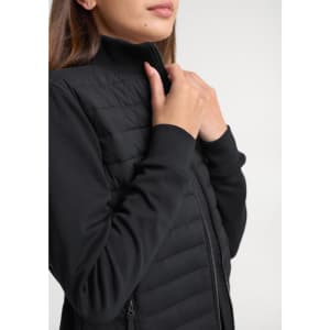 A women's tailored jacket in black, featuring a zip closure and quilted design on the body.