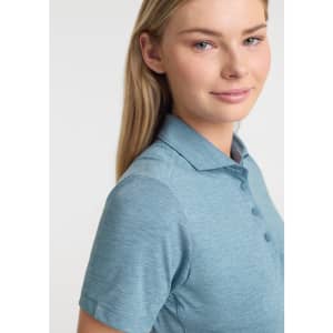 A women's short sleeve polo in a soft blue colour, featuring a collar and buttons, with a logo on the front.