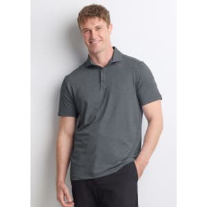 A man wearing a grey short sleeve polo shirt, standing casually with a friendly expression. The shirt has a collar and branding.