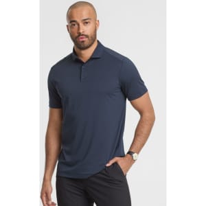 A short sleeve polo shirt in navy blue, featuring a collar and a logo on the chest, worn by a male model.