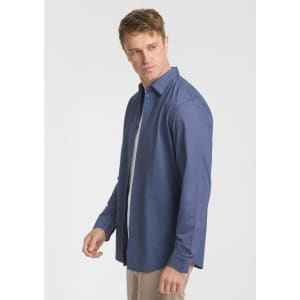 A long sleeve shirt in navy blue, featuring a relaxed fit and a subtle texture. It includes a logo on the label.