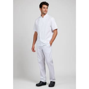 A white short sleeve chef jacket worn by a man, paired with white trousers and black shoes, featuring a logo.