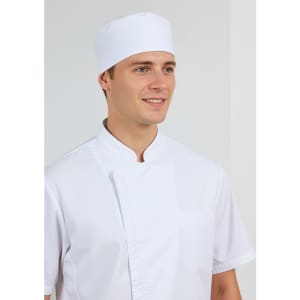 A white short sleeve chef jacket worn by a smiling man, paired with a matching white chef hat.