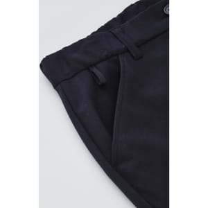 A close-up of navy women's cargo pants featuring a comfort waist and side pockets, with a logo on the fabric.