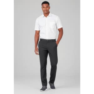 A man wearing black flat front slacks paired with a white short-sleeve shirt and grey sneakers. There is a logo on the slacks.