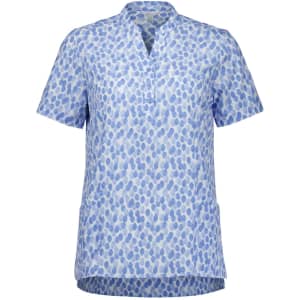 A blue and white tunic featuring a stardust print, with a v-neck and short sleeves. It has a branding logo.