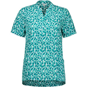 A short-sleeved tunic in a teal and white stardust print, featuring a collar and side pockets. It has a logo.