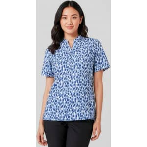 A woman wearing a short-sleeved tunic in a blue stardust print, featuring a collar and a relaxed fit.
