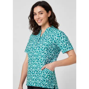 A tunic featuring a teal and white stardust print, with short sleeves and a pocket, displayed on a model.