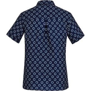 A navy short sleeve shirt with a white daisy print and a back pleat detail. It features a collar and one logo.