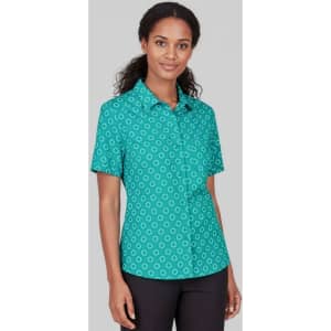 A short sleeve shirt in teal featuring a daisy print pattern and a button-up front. The model poses against a neutral background.