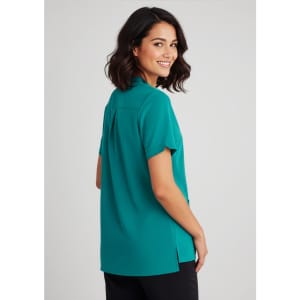 A woman wearing a teal plain tunic, showcasing a relaxed fit and short sleeves, with a back view visible.