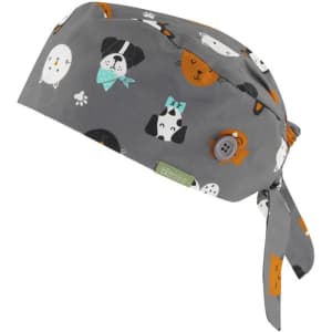 A unisex printed scrub cap in grey featuring various cartoon dogs in multiple colours and a button detail.