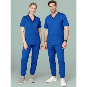 A pair of models wearing matching blue scrub tops and slim-leg jogger scrub pants, featuring branding.
