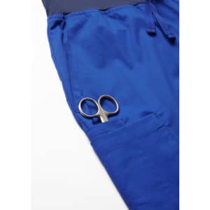 A pair of scissors tucked into the pocket of blue jogger scrub pants.