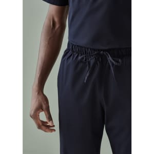 A unisex pair of navy scrub pants with an elastic waistband and adjustable drawstring, featuring a hand on the side.