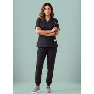 A black women's scrub top featuring a V-neck design, paired with matching black scrub pants and sneakers.
