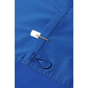 A close-up of a blue scrub top featuring a white toggle and a small metal clip.