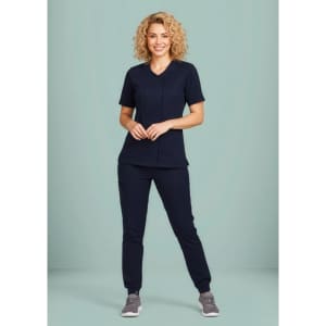 A women's navy scrub top with a zip front and crossover design, paired with matching pants, displayed on a model.