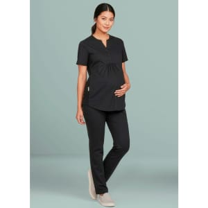 A black women's scrub top with a buttoned neck design, worn by a pregnant model, paired with black pants.