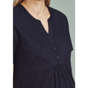 A women's navy tunic scrub top featuring a notch neckline and button detail. The top has a relaxed fit.