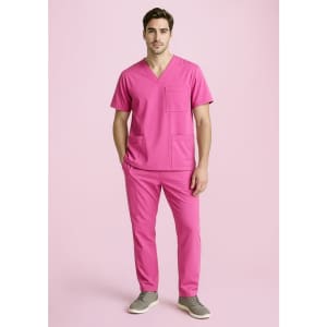 A unisex pink V-neck scrub top with two pockets, paired with matching pink pants and grey shoes.