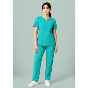 A women's scrub top in teal, featuring a round neck and two front pockets, styled with matching pants.