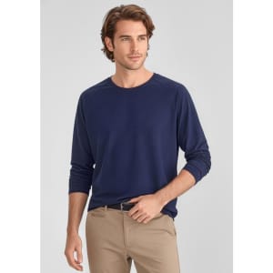 A navy long sleeve tee for men, featuring a relaxed fit and a logo. Paired with light-coloured pants.