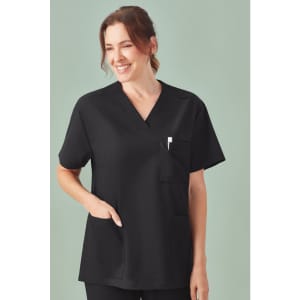 A unisex black V-neck scrub top featuring short sleeves and a pocket. The model is smiling against a soft green background.