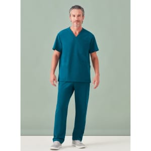 A man wearing a teal unisex pulse V-neck scrub top and matching scrub pants, featuring a plain design and a logo.