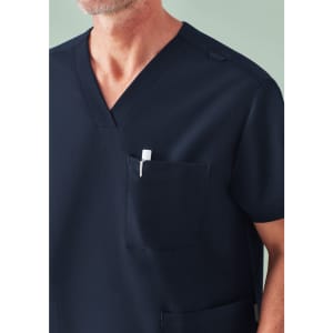 A navy unisex scrub top featuring a V-neck design and a chest pocket with a pen. It includes a logo.