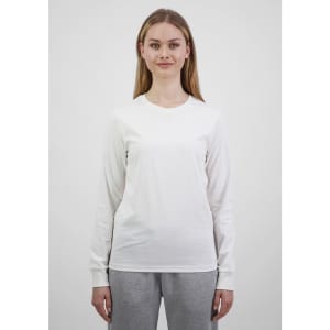 A long sleeve white tee for women displayed on a model, featuring a simple design and a fitted silhouette.