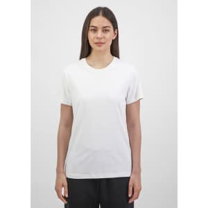 A short sleeve tee in white, featuring a crew neckline and a fitted style, displayed by a model.