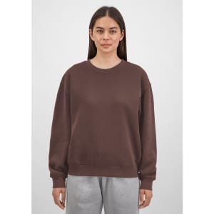 A brown crew sweatshirt for women, featuring a relaxed fit and long sleeves, displayed on a model.