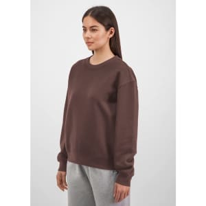A brown crew sweatshirt with long sleeves, featured on a model against a light background.