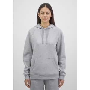 A grey women's hoodie with a front pocket and drawstring hood, featuring a logo on the sleeve.