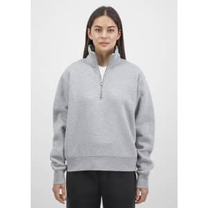 A grey women's 1/4 zip sweatshirt with a high collar and long sleeves, featuring a simple design and logo.
