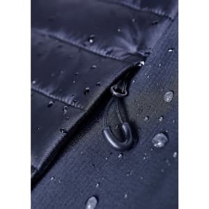 A close-up of a black soft shell jacket featuring a zippered opening and water droplets on the fabric.