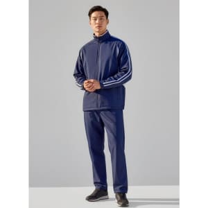 A model wearing unisex navy track pants paired with a matching zip-up jacket featuring white stripes.