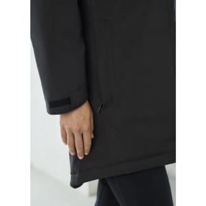 A black unisex rain jacket featuring a hand elegantly positioned near the hem, demonstrating its sleek design.