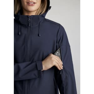 A woman wearing a navy jacket with a zippered pocket on the sleeve, featuring a logo on the jacket.