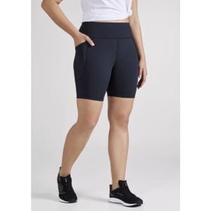 A pair of women's navy bike shorts with side pockets and a high waistband, displayed on a model.